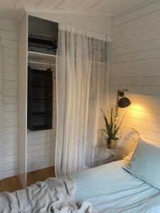 DomsjöPeaceful and Scandinavian-style Guesthouse with Scenic Nature and Seaview in High Coast的一间卧室配有一张带白色窗帘的床