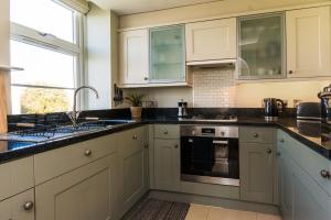 托基Stunning Sea View Central Torbay Home with Parking的厨房配有白色橱柜和黑色台面