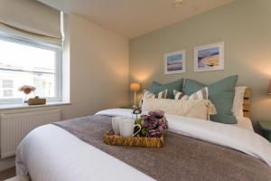 托基Stunning Sea View Central Torbay Home with Parking的一间卧室,配有一张带鲜花托盘的床