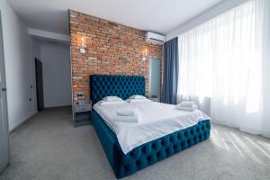 克卢日-纳波卡泽罗旅馆的一间卧室设有蓝色的床和砖墙