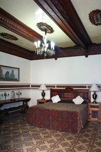 普埃布拉卡萨德拉帕尔马精品酒店的一间卧室配有一张大床和一个吊灯。