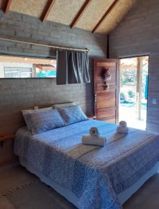 圣安东尼奥-杜皮尼亚尔Chalé na Montanha的一间卧室配有一张带蓝色棉被的床