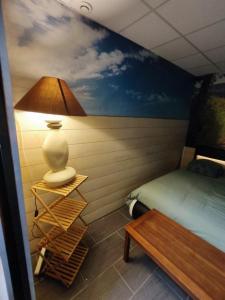 Oye-PlageLOVE SPA的一间卧室配有一张床、一盏灯和一张桌子