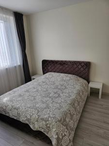 克雷廷加Family apartment的一间卧室配有一张带灰色棉被的床和窗户