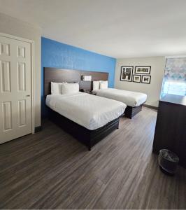 斯塔福德休斯顿斯塔福德舒格兰拉昆塔套房酒店的两张位于酒店客房的床,拥有蓝色的墙壁