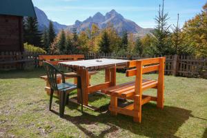 AndrijevicaKOMOVI- kobildo SMJESTAJ的野餐桌和两把椅子,背景是山脉
