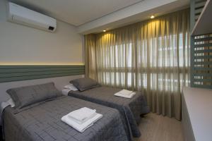 本图贡萨尔维斯Apto Luxo Vila di Tondo Area Lazer na Cobertura的一间卧室设有两张单人床和一个窗户。