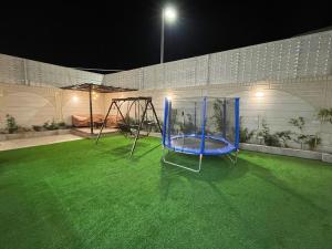 阿哈达شاليهات وجدان الهدا的夜晚在院子里的一个蓝色游乐场
