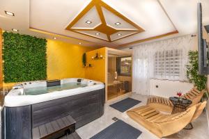 科普里夫尼察Lotus Wellness & spa apartman的一间带热水浴缸和椅子的大浴室