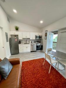 劳德代尔堡Modern Riverview Apartments的厨房配有沙发和红色地毯的桌子