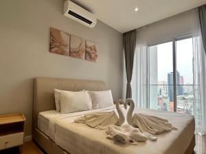 吉隆坡Quill Suites KLCC的两个天鹅坐在卧室的床上