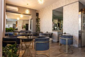 蒙特雷Hotel Boutique de Firma的餐厅设有蓝色的桌椅和镜子