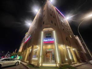 利雅德السعادة سويت - الملز الرياض Saada Suites Serviced Apartments的一座晚上有标志的建筑