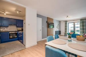 贝尔法斯特Citygate Central Apartments的厨房以及带桌椅的起居室。