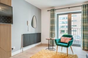 贝尔法斯特Citygate Central Apartments的客厅配有绿色椅子和桌子