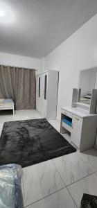 阿布扎比Hotel rooms inside private Apartment for Rent at Tourist Club Area的一间设有书桌的客房,地板上铺有地毯。