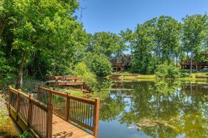 InnsbrookLakeview Hideaway by Sarah Bernard Chalets, with Firepit and Private Dock on a Quiet Lake的一座湖上的木桥,后面有一座房子