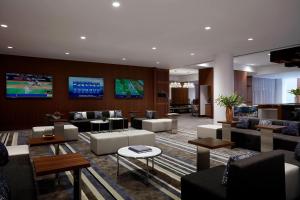 尤宁戴尔长岛万豪酒店的大堂配有沙发、椅子和电视。