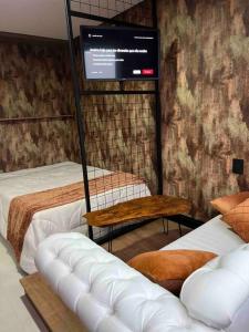 本图贡萨尔维斯Lindo e aconchegante的客房设有两张床和一台平面电视。