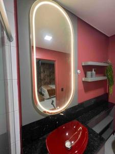 本图贡萨尔维斯Lindo e aconchegante的一间带红色水槽和镜子的浴室
