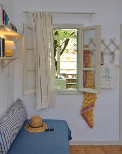 斯特尼瓦拉阿奥索斯Casa Kalypso的一间设有窗户的房间,沙发上有一顶帽子