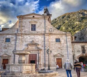 Pratola PelignaCasa vacanza da Anna 2的一座古老的石头建筑,设有钟楼和喷泉