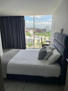 巴兰基亚Hotel OR Suites的一间卧室设有一张大床和大窗户