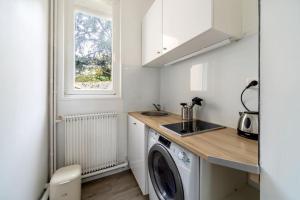 圣阿德雷斯Studio proche plage的厨房配有洗衣机和水槽