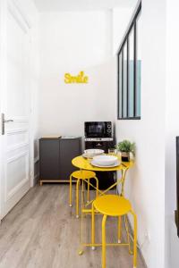 圣阿德雷斯Studio proche plage的厨房配有黄色的椅子、桌子和炉灶