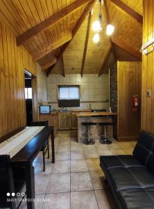 波韦尼尔Hotel y Cabañas Pulegan的厨房设有木墙、桌子和电视。