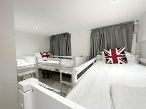 伦敦205 Earls Court Rooms的白色的客房设有两张床和窗户。