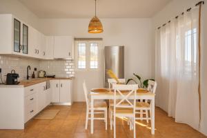 伊奥斯乔拉Anemos house Ios的白色的厨房配有桌椅