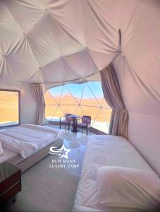 瓦迪拉姆RUM ATANA lUXURY CAMP的一间位于大帐篷内的卧室,配有两张床