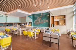西安西安浐灞艾美酒店的用餐室配有桌子和黄色椅子