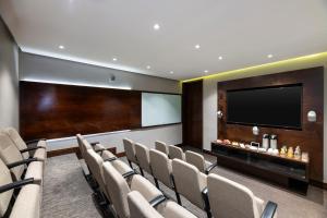 波哥大Hotel 93 Luxury Suites by Preferred的一间会议室,配有椅子和平面电视