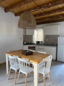 La ConsultaLos Andes de Uco的厨房配有木桌和白色椅子