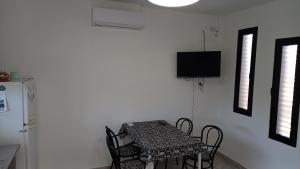 波萨达斯Casa Costa Sur的一间带桌椅和电视的用餐室