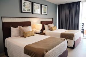 马萨特兰马萨特兰酒店的酒店客房设有两张床和窗户。