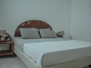 BeironaVila Paradise Sea & Swimming Pool View的卧室内的一张带白色床单和枕头的床