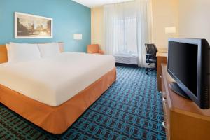 奥斯汀奥斯汀大学区费尔菲尔德酒店及套房的配有一张床和一台平面电视的酒店客房