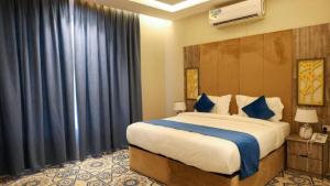 吉赞برج بيات的一间卧室配有一张带蓝色窗帘的大床