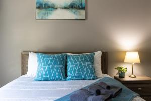 雷夫尔斯托克The Mackenzie Haven的一间卧室配有一张带蓝色和白色枕头的床