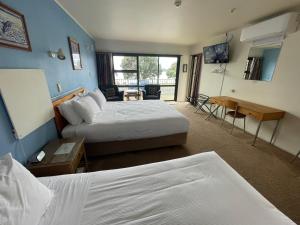 派西亚金沙湾海滨一室公寓的酒店客房配有两张床和一张书桌
