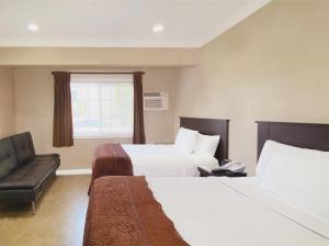 洛杉矶Nite Inn at Universal City - Walking Distance to Universal Studios Hollywood的酒店客房,设有两张床和一张沙发