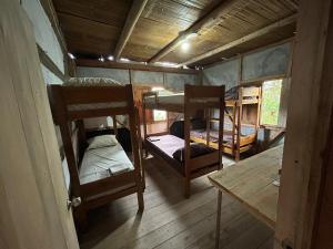 莫姆皮切Hostal Camping Sin Fronteras Mompiche的客房设有两张双层床和一张桌子。