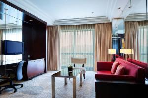 杭州杭州龙禧福朋喜来登酒店的客厅配有红色沙发和电视