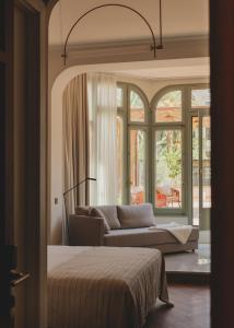 巴塞罗那Casa Llimona Hotel Boutique的卧室配有一张床,窗户前配有一张沙发