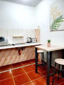 独鲁万Studio type unit - Host Homes Apitong的厨房配有柜台、桌子和凳子