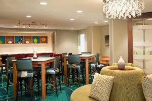 杰克逊维尔Springhill Suites Jacksonville的一间带桌椅和吊灯的餐厅