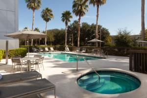 杰克逊维尔Springhill Suites Jacksonville的一个带桌椅和棕榈树的游泳池